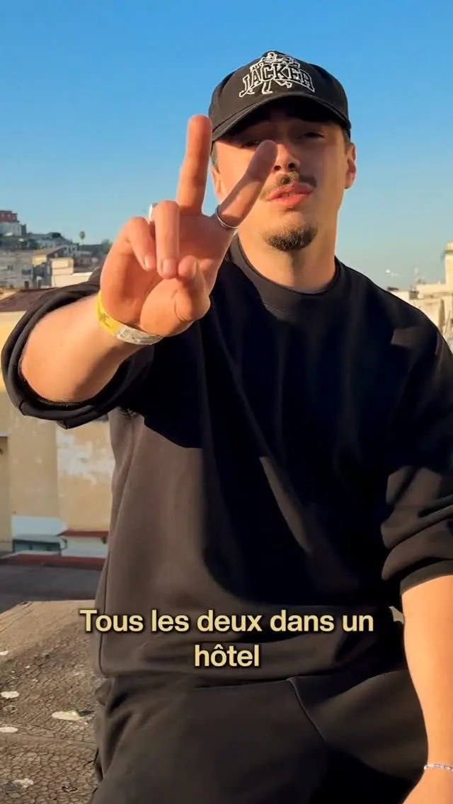 MaxxBud fait un signe de paix sur un toit au soleil